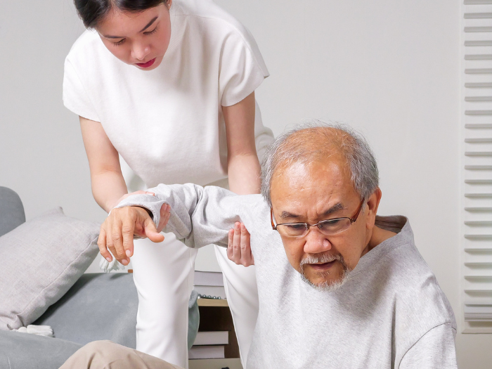 Caretaker helping a man after a fall